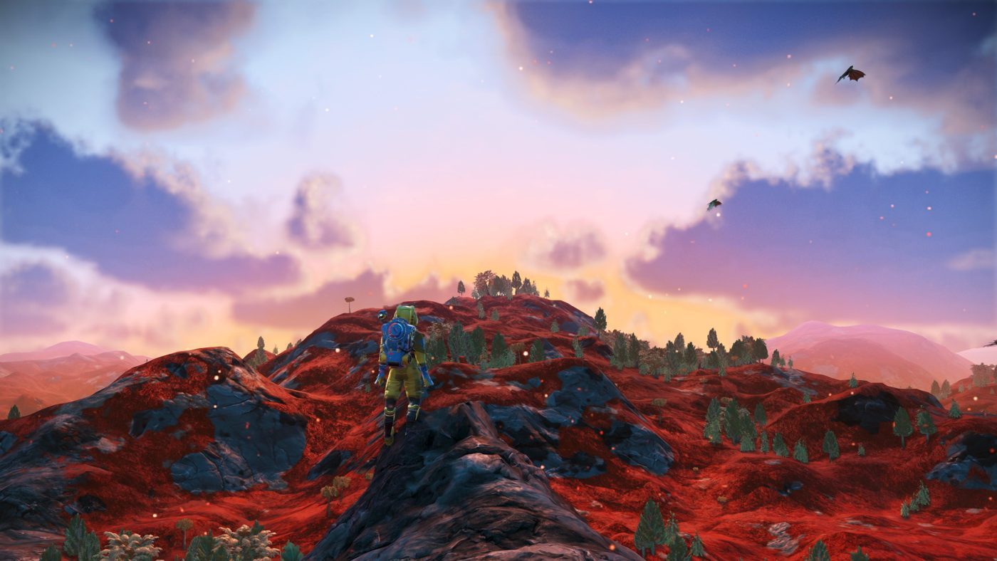 No Man's Sky: a distant astronaut on a dark rock under a rainbow and a pink and yellow sky