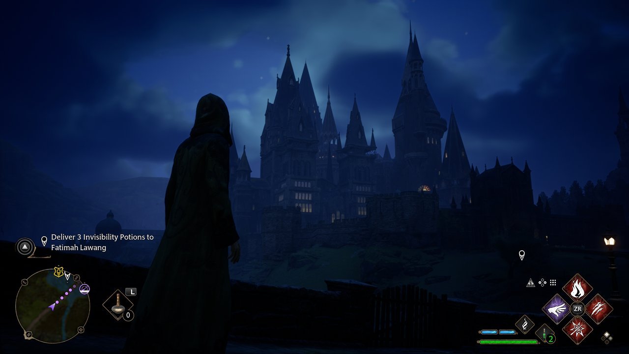 Hogwarts Legacy: the castle with lit windows against a deep blue night sky
